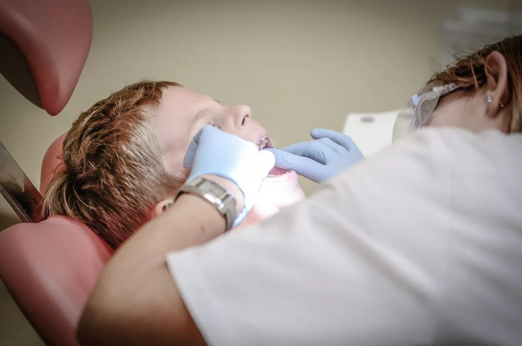 A dentist looking and a child's teeth