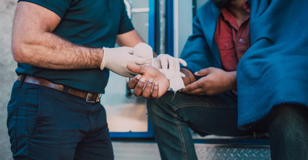 A paramedic bandaging up and arm